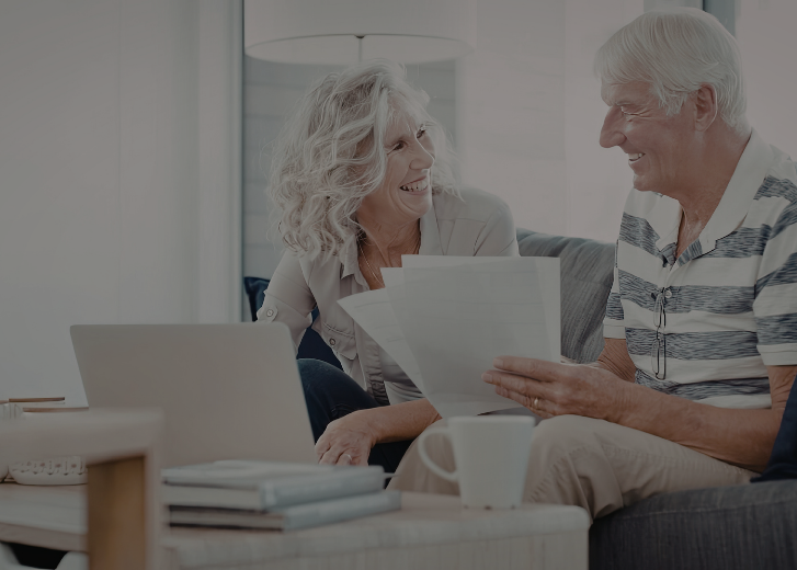 older couple smiling over paperwork